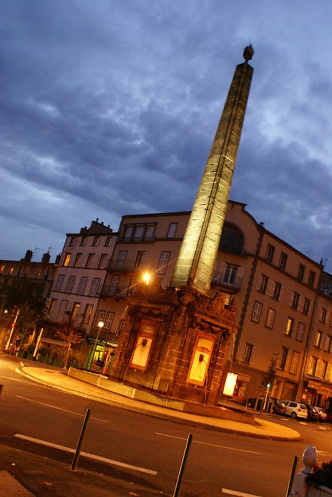 Illuminated monument in front of a historic building, Puy-de-Dôme