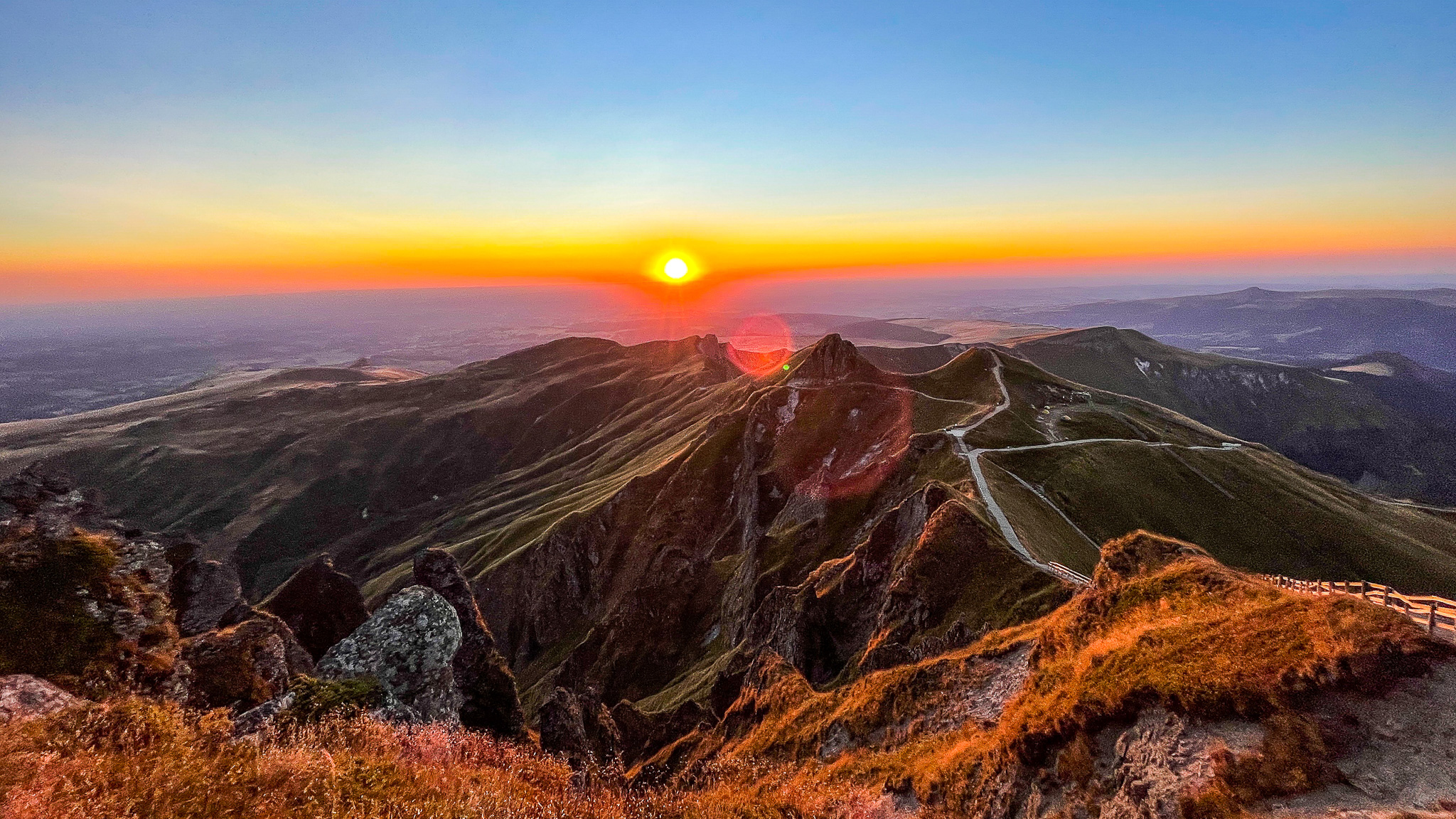 Pas de l'Ane: Golden Sunset over Puy Redon and the Tour Carrée - An Unforgettable Spectacle